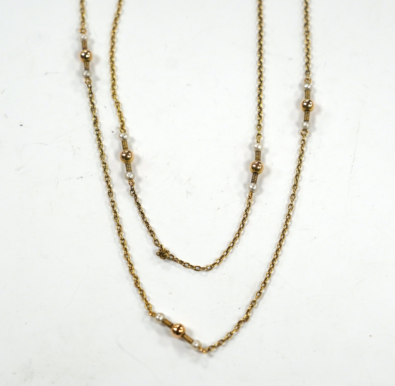 A 10k yellow metal and seed pearl set guard chain, 146cm, gross weight 14.2 grams.